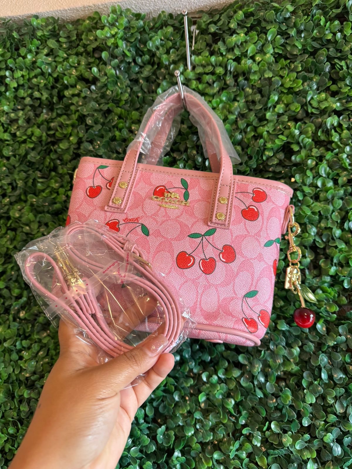 A BOLSA COACH ROSA CON LLAVERO CEREZAS