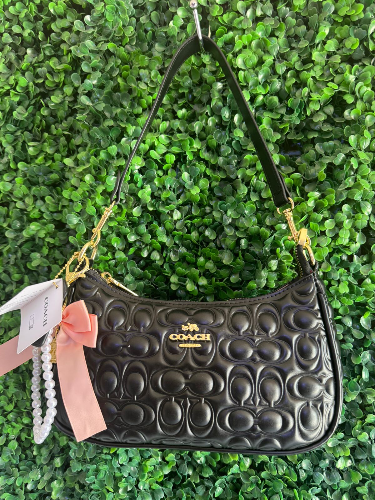 A BOLSA NOLITA COACH NEGRA CON LLAVERO DE PERLAS