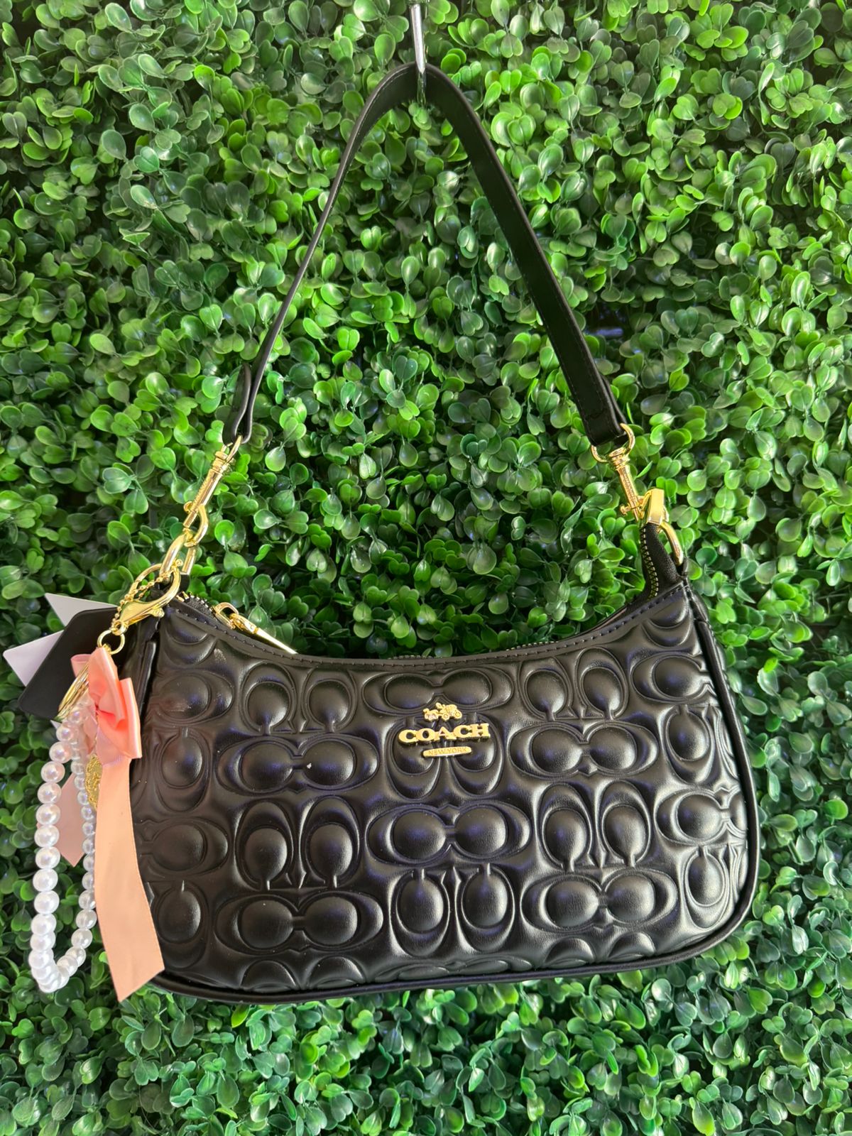 A BOLSA NOLITA COACH NEGRA CON LLAVERO DE PERLAS