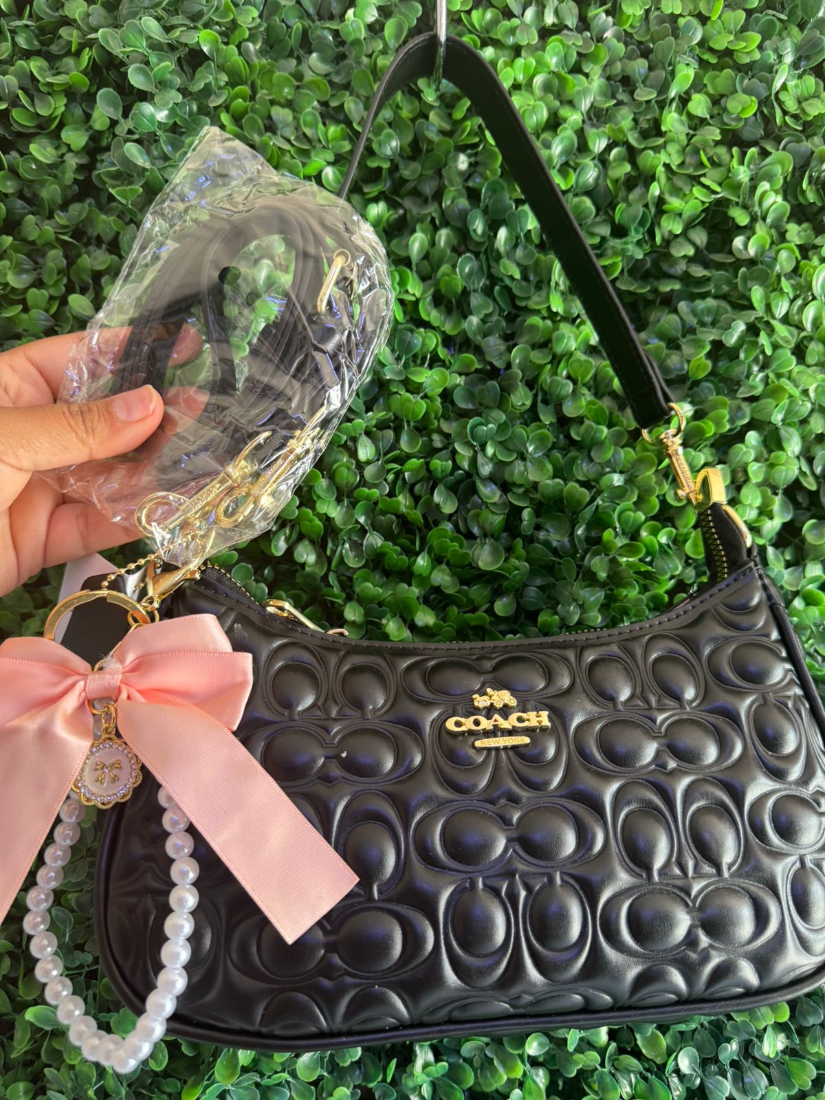 A BOLSA NOLITA COACH NEGRA CON LLAVERO DE PERLAS