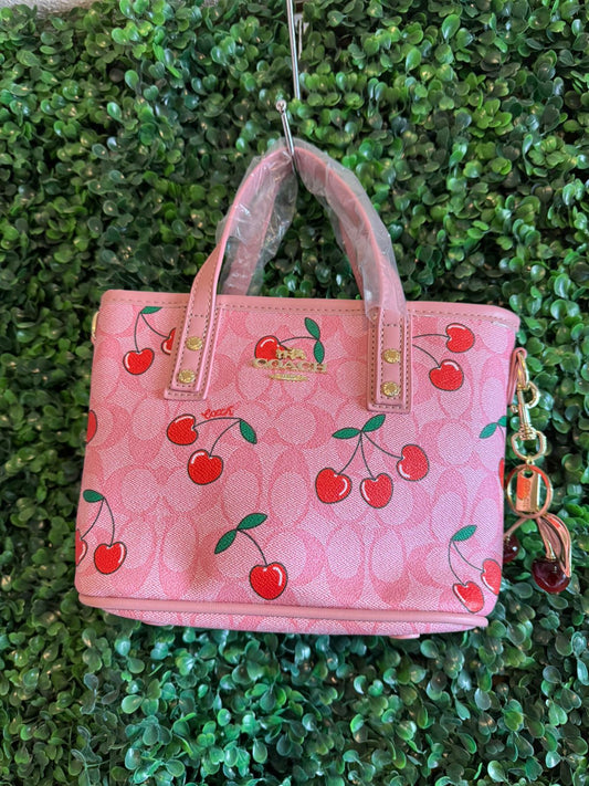 A BOLSA COACH ROSA CON LLAVERO CEREZAS