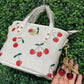 A BOLSA COACH CON LLAVERO DE CEREZA